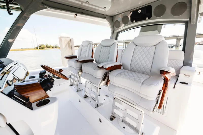 Slide: The Image of Luxurious helm seating on 2026 HCB 48 Campeón boat, featuring elegant white leather and wood accents. - 16