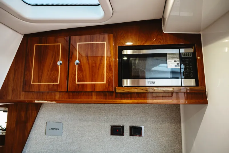 Slide: The Image of Luxurious interior of 2026 HCB 48 Campeón yacht featuring wood cabinetry and built-in microwave. - 28