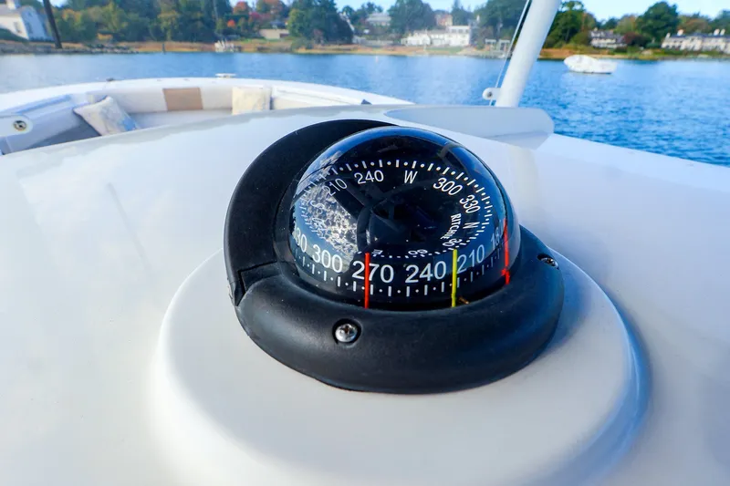 Slide: The Image of Compass on 2015 Southport 33 FE boat, with scenic water and shoreline background. - 7