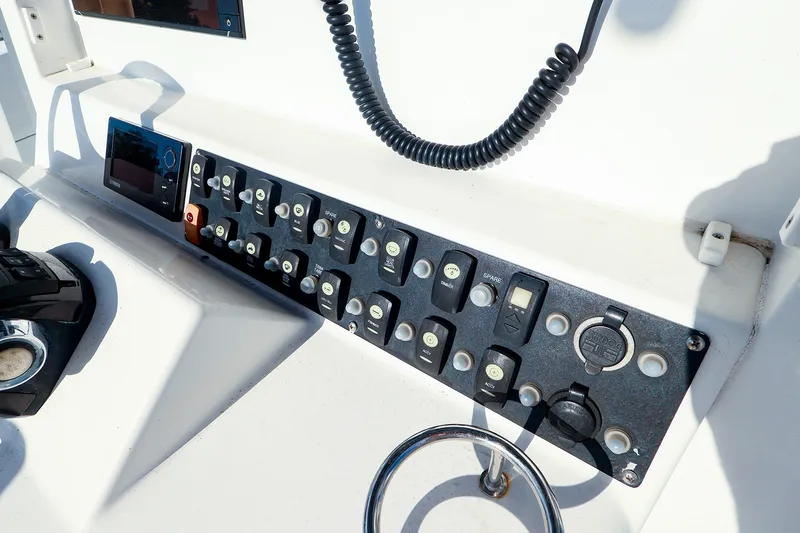 Slide: The Image of Control panel of a 2015 Southport 33 FE boat with various switches and a coiled cable. - 8