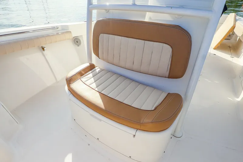 Slide: The Image of 2015 Southport 33 FE boat seat with tan and white upholstery, on a sunny day. - 15