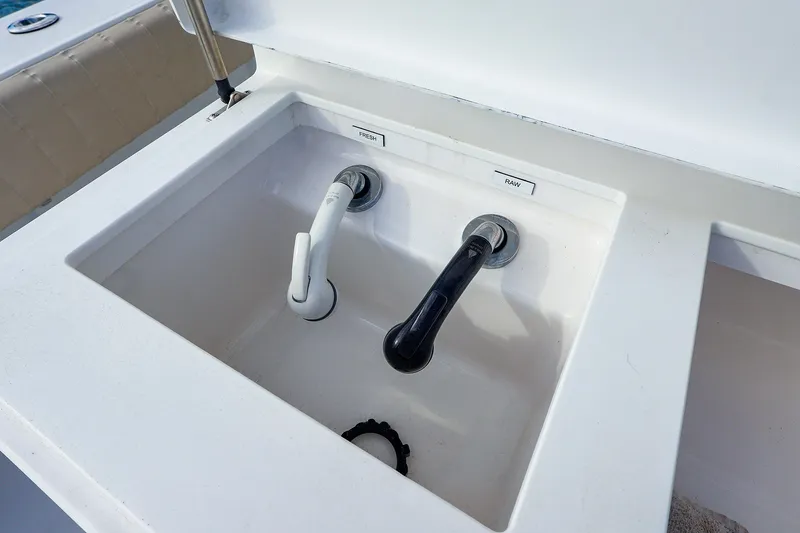 Slide: The Image of Sink with fresh and raw water faucets on a 2015 Southport 33 FE boat. - 28