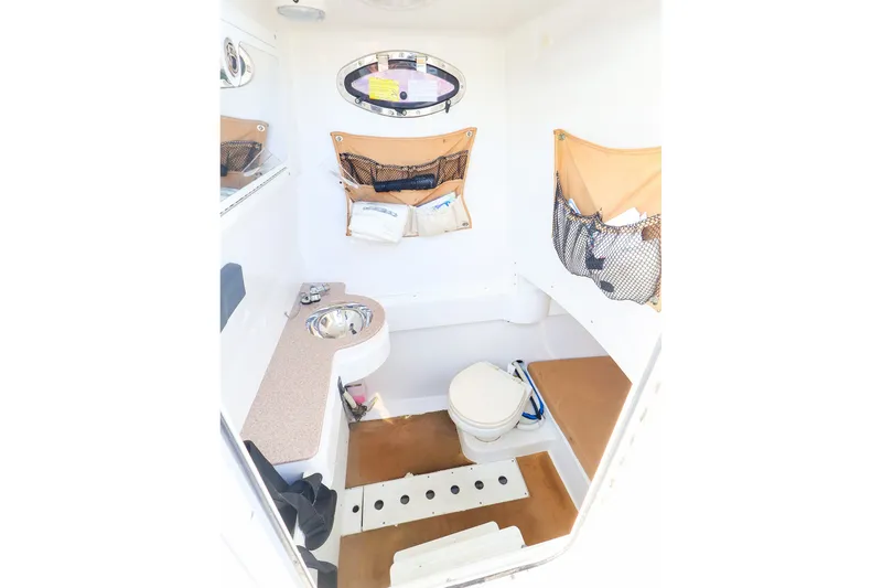 Slide: The Image of Interior of 2015 Southport 33 FE boat featuring compact bathroom amenities. - 11