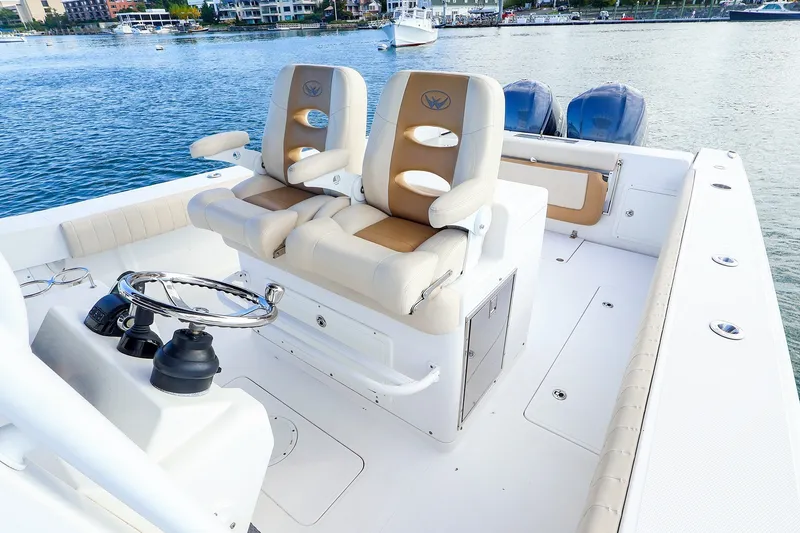 Slide: The Image of 2015 Southport 33 FE boat interior with dual seats and steering wheel on calm water. - 3