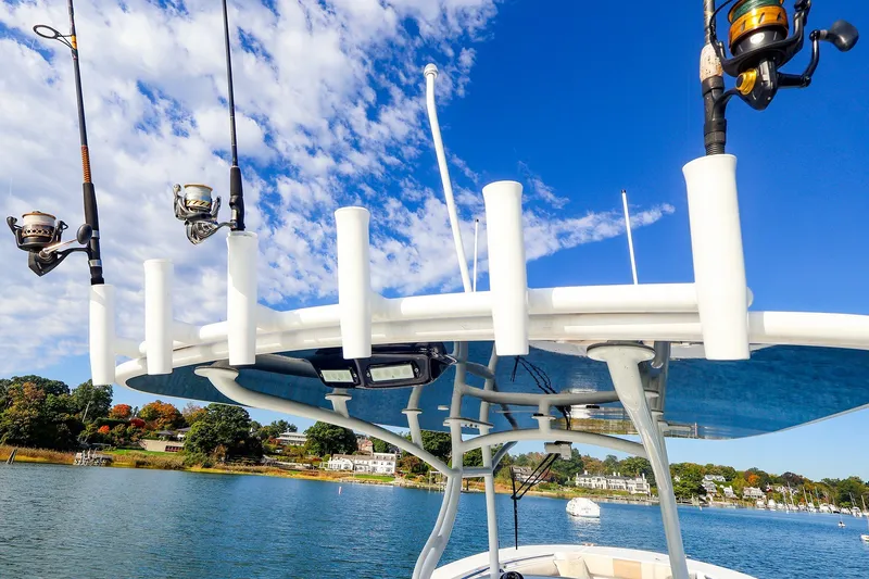 Slide: The Image of Fishing rods on a 2015 Southport 33 FE boat against a scenic waterfront backdrop. - 19