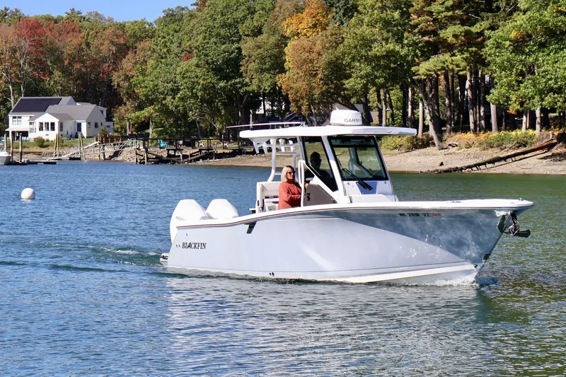 Slide: The Image of 2023 Blackfin 272 CC boat cruising on a scenic lake with autumn foliage. - 3