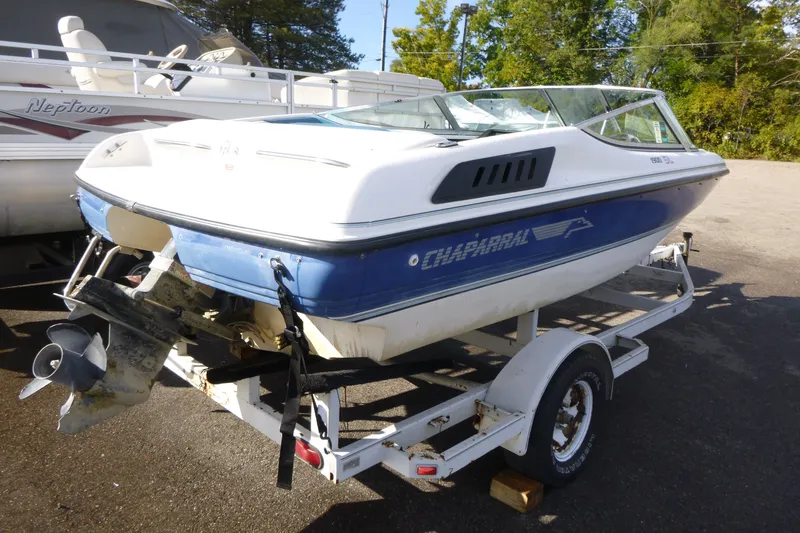 Slide: The Image of 1992 Chaparral boat on trailer, blue and white, parked outdoors. - 1