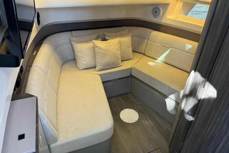 Slide: The Image of Interior of the 2021 Sea Ray SLX 400 Outboard with beige corner sofa and cushions. - 42