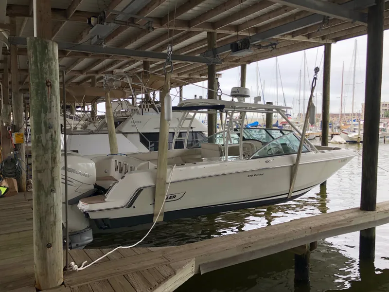 The Image of A 2017 Boston Whaler 270 Vantage is docked in a covered marina. - 0