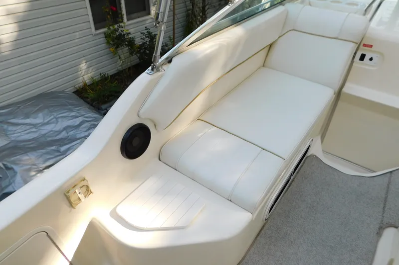 Slide: The Image of Interior seating of a 1996 Sea Ray 250 Sundancer boat, featuring white upholstery. - 40