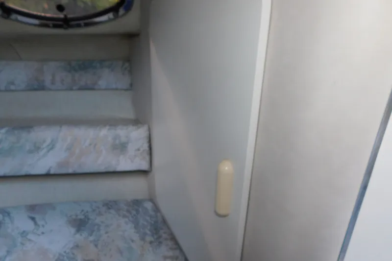Slide: The Image of Interior stairs of a 1996 Sea Ray 250 Sundancer boat, featuring patterned upholstery. - 52