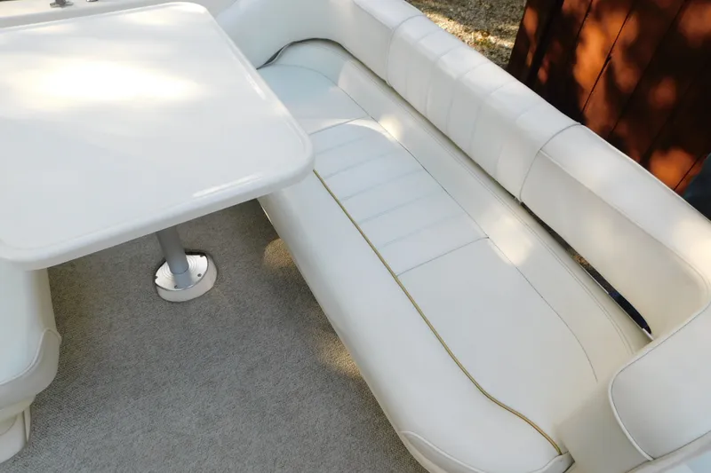 Slide: The Image of Interior seating and table of a 1996 Sea Ray 250 Sundancer boat. - 30
