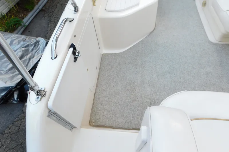 Slide: The Image of 1996 Sea Ray 250 Sundancer boat interior with white seating and carpeted floor. - 25