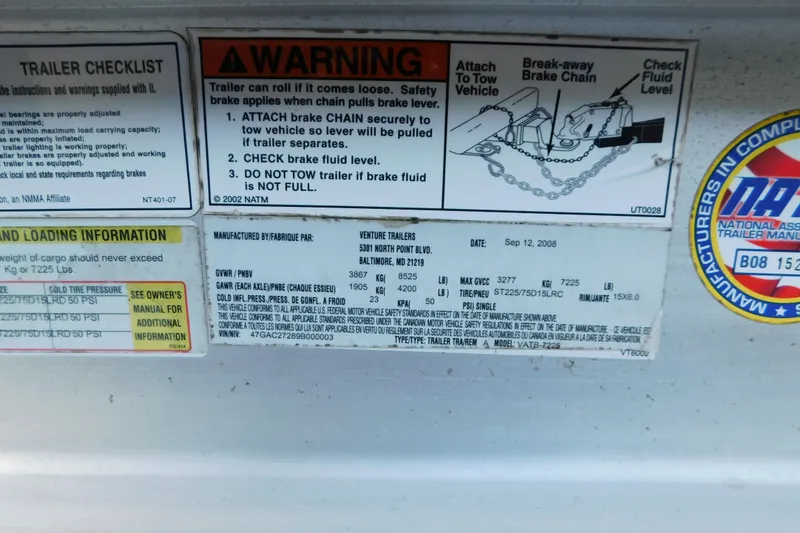 Slide: The Image of Warning and checklist labels on a 1996 Sea Ray 250 Sundancer trailer. - 19