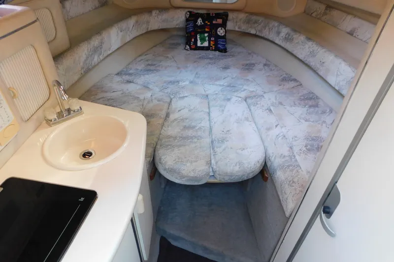 Slide: The Image of Interior of a 1996 Sea Ray 250 Sundancer boat with cozy sleeping area and sink. - 77