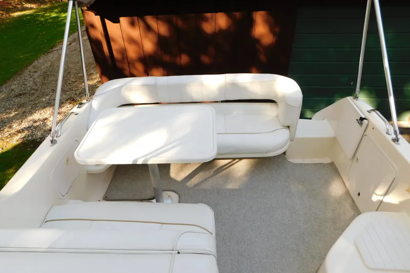 Slide: The Image of 1996 Sea Ray 250 Sundancer boat interior with white seating and table. - 42