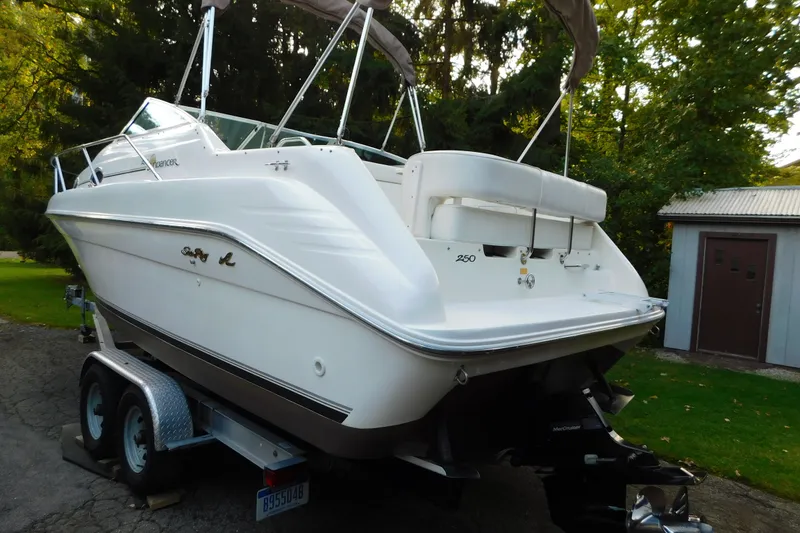Slide: The Image of 1996 Sea Ray 250 Sundancer boat on trailer, parked outdoors near trees and shed. - 8