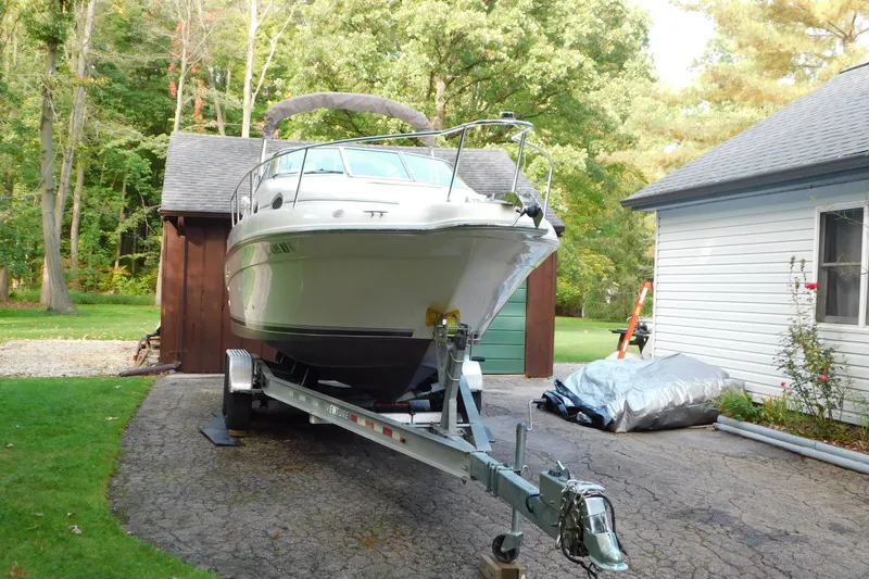 Slide: The Image of 1996 Sea Ray 250 Sundancer boat on trailer, parked in driveway near garage and trees. - 3