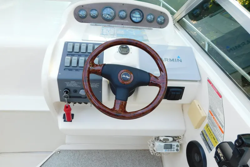 Slide: The Image of 1996 Sea Ray 250 Sundancer helm with wood steering wheel and Garmin navigation system. - 33