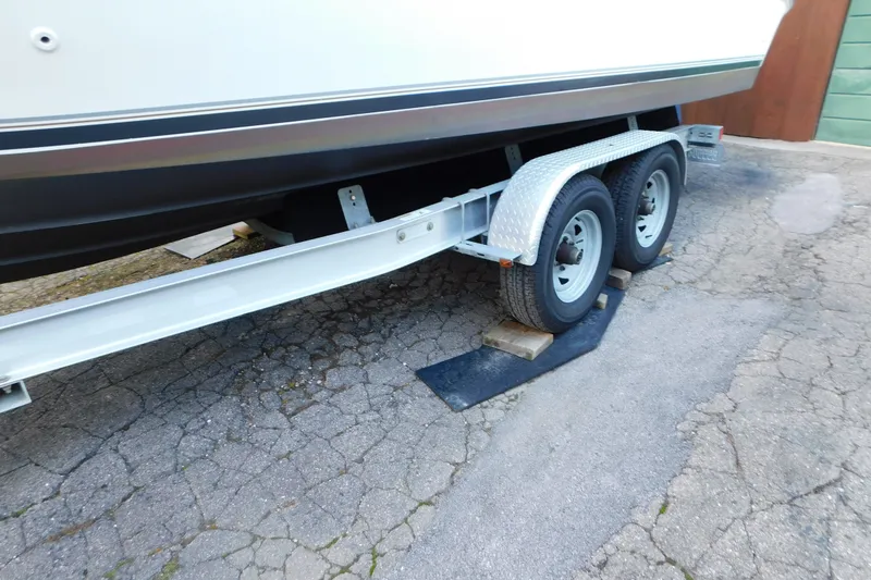 Slide: The Image of Trailer supporting a 1996 Sea Ray 250 Sundancer boat on a paved surface. - 22
