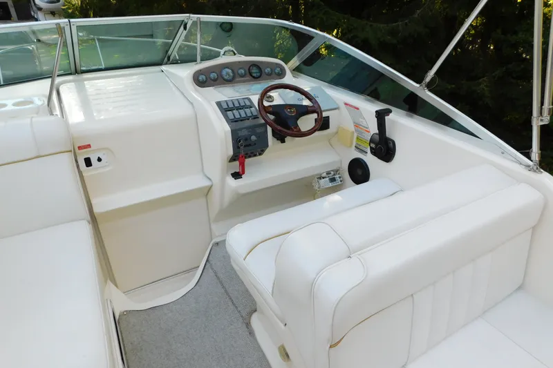 Slide: The Image of 1996 Sea Ray 250 Sundancer boat cockpit with white seating and control panel. - 31
