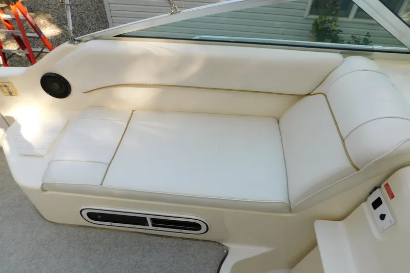 Slide: The Image of Interior seating of a 1996 Sea Ray 250 Sundancer boat, featuring white upholstery. - 46