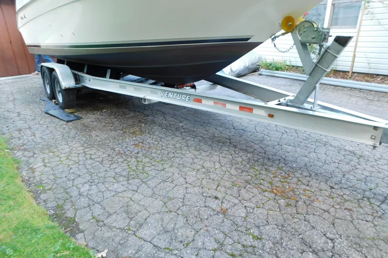 Slide: The Image of 1996 Sea Ray 250 Sundancer on a Venture trailer, parked on a paved driveway. - 17