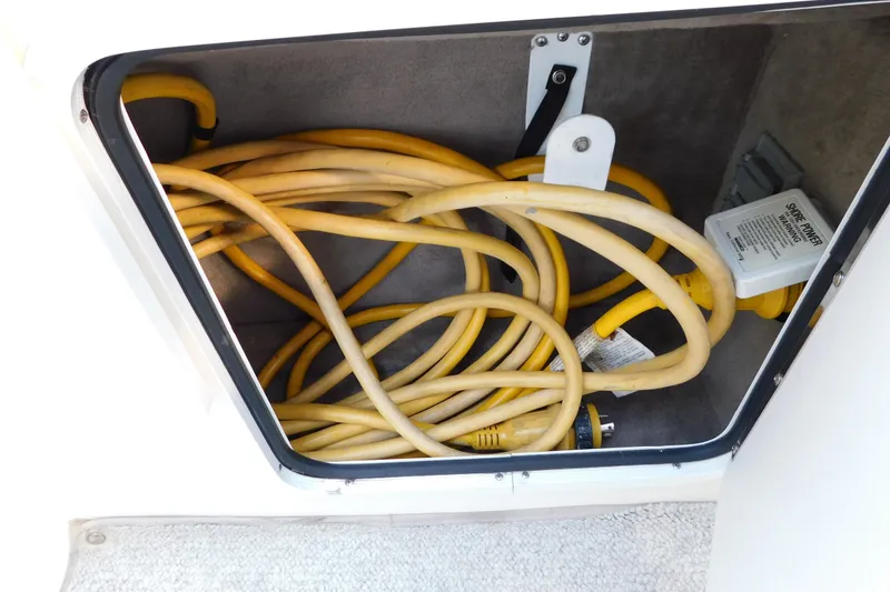 Slide: The Image of Yellow power cables stored in a compartment of a 1996 Sea Ray 250 Sundancer boat. - 76