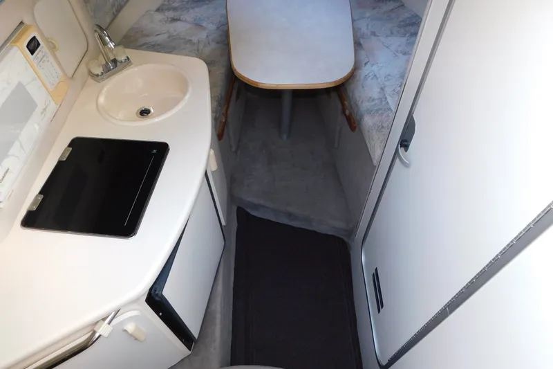 Slide: The Image of Interior of 1996 Sea Ray 250 Sundancer boat with kitchenette and seating area. - 50