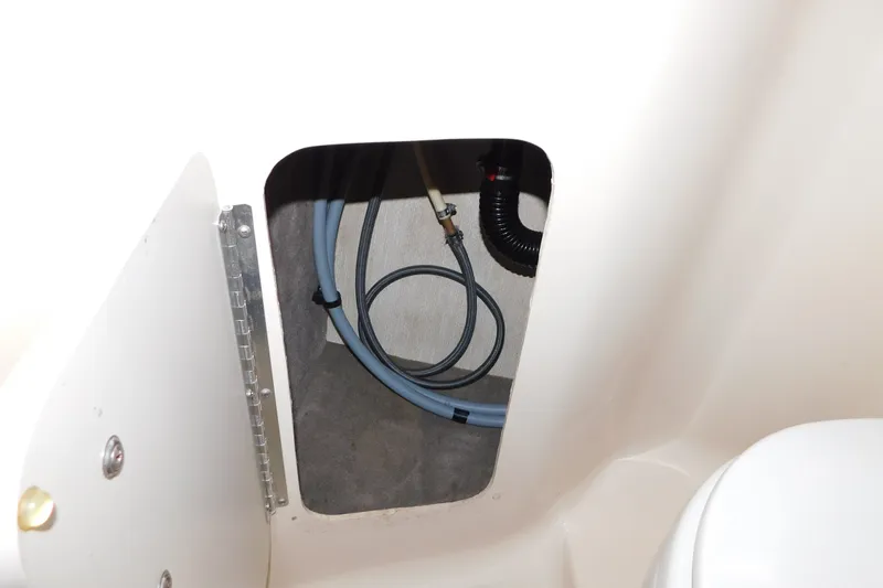 Slide: The Image of 1996 Sea Ray 250 Sundancer interior compartment with visible hoses and plumbing. - 72