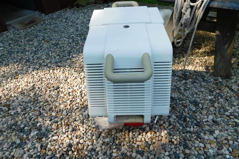 Slide: The Image of Portable air conditioner on gravel, near a 1996 Sea Ray 250 Sundancer boat. - 91