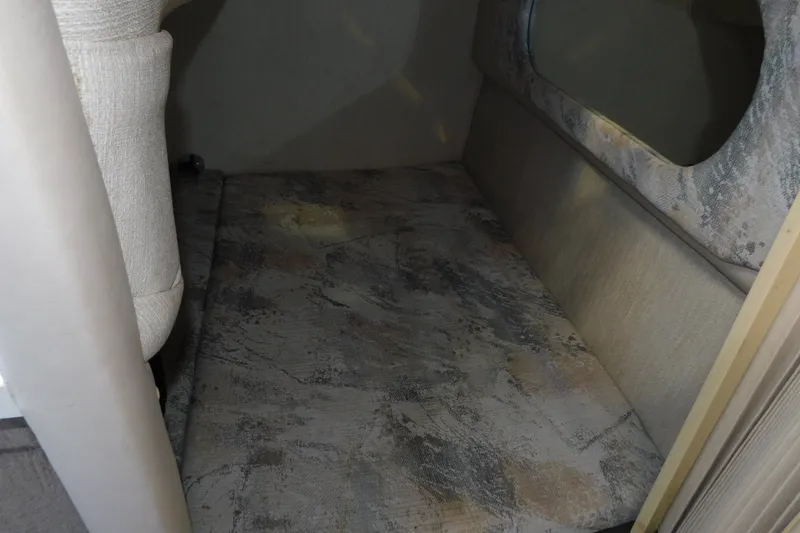 Slide: The Image of Interior cabin of a 1996 Sea Ray 250 Sundancer boat, featuring a cushioned seating area. - 63