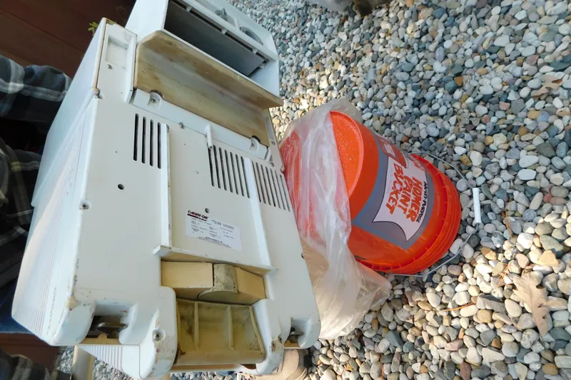 Slide: The Image of Old air conditioning unit on gravel beside an orange bucket. - 96