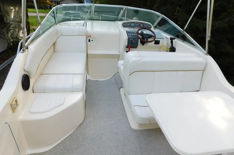 Slide: The Image of 1996 Sea Ray 250 Sundancer boat interior with white seating and steering console. - 28