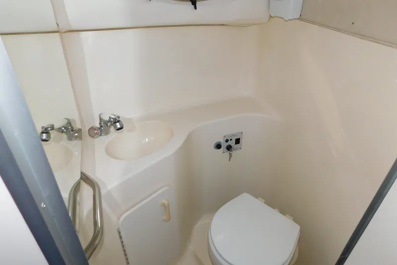 Slide: The Image of Bathroom interior of 1996 Sea Ray 250 Sundancer boat, featuring sink and toilet. - 71
