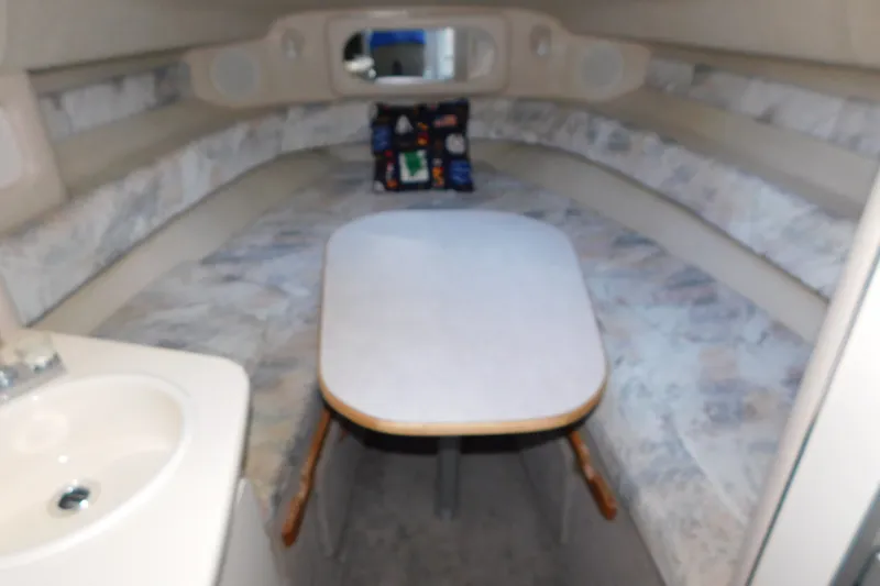 Slide: The Image of Interior cabin of a 1996 Sea Ray 250 Sundancer with table and seating. - 51