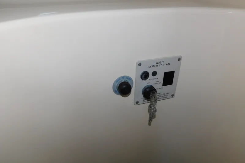 Slide: The Image of Control panel of a 1996 Sea Ray 250 Sundancer waste system with key and switches. - 70