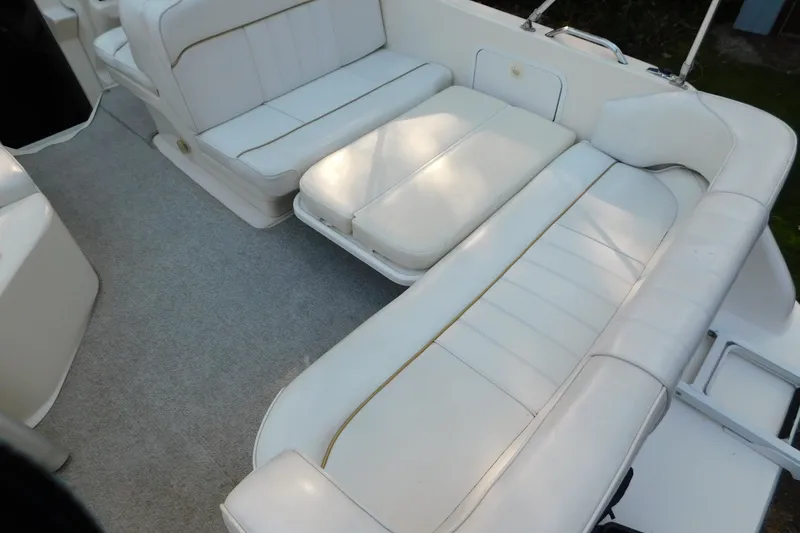 Slide: The Image of 1996 Sea Ray 250 Sundancer boat interior with white cushioned seating. - 75