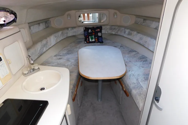 Slide: The Image of Interior of a 1996 Sea Ray 250 Sundancer boat with a cozy cabin and kitchenette. - 49