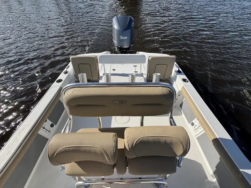 Slide: The Image of The image shows the cockpit of a 2018 Sea Hunt BX25BR with beige seats and an outboard motor. - 13