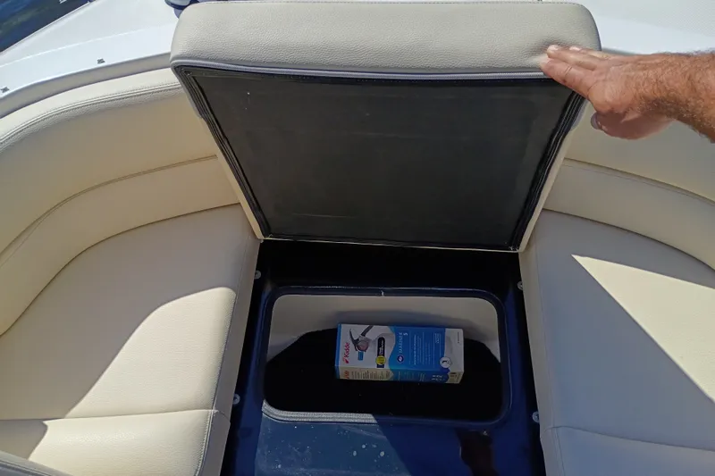 Slide: The Image of 2021 Regal 29 OBX boat seat storage compartment with a box inside. - 18