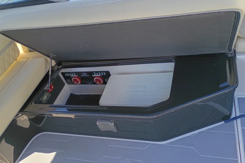 Slide: The Image of 2021 Regal 29 OBX boat storage compartment with control panel and Igloo cooler. - 40