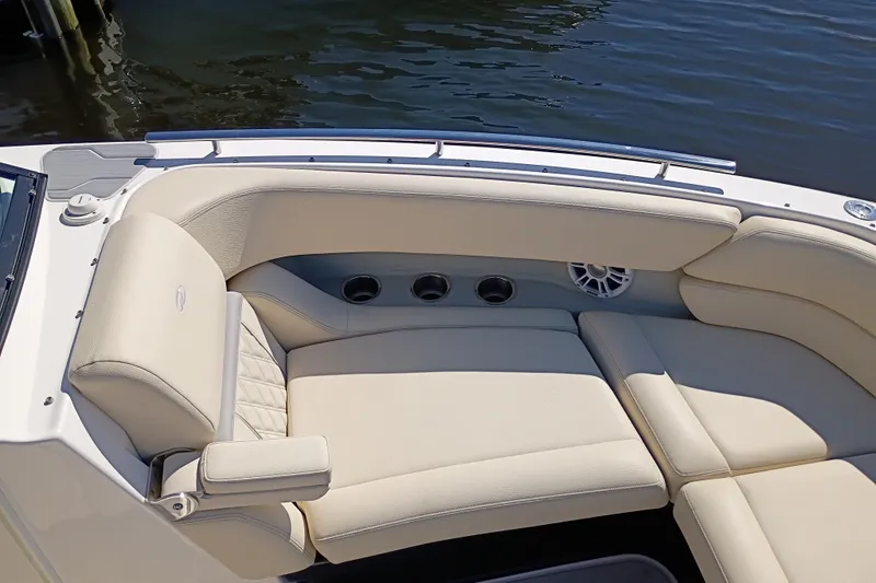 Slide: The Image of Luxurious seating on a 2021 Regal 29 OBX boat, featuring beige upholstery and cup holders. - 19
