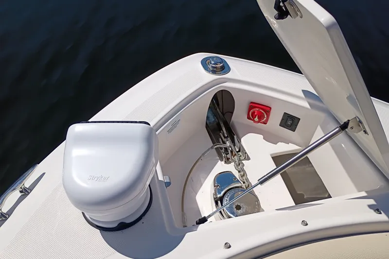 Slide: The Image of 2021 Regal 29 OBX boat anchor compartment with open hatch and visible chain mechanism. - 17
