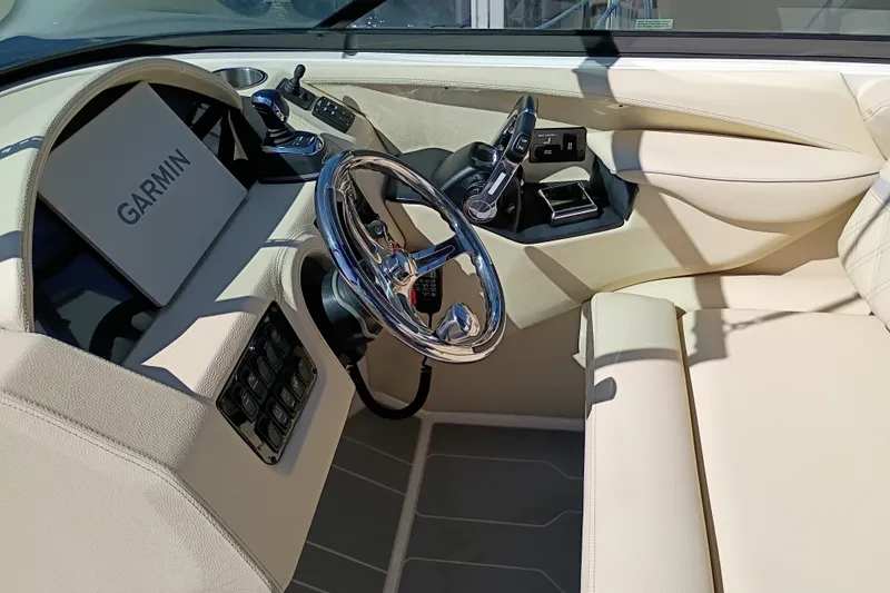 Slide: The Image of 2021 Regal 29 OBX boat cockpit with Garmin navigation, luxurious beige interior, and chrome steering wheel. - 14