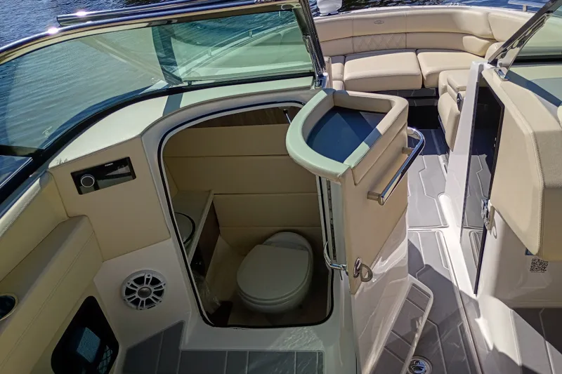 Slide: The Image of 2021 Regal 29 OBX boat interior with seating and compact restroom. - 44