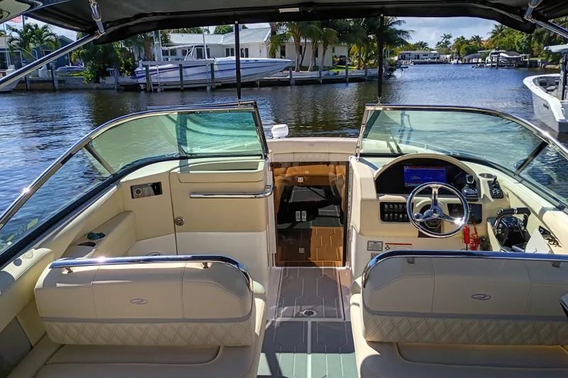 Slide: The Image of 2021 Regal 29 OBX boat interior with luxurious seating and modern dashboard on a sunny day. - 42