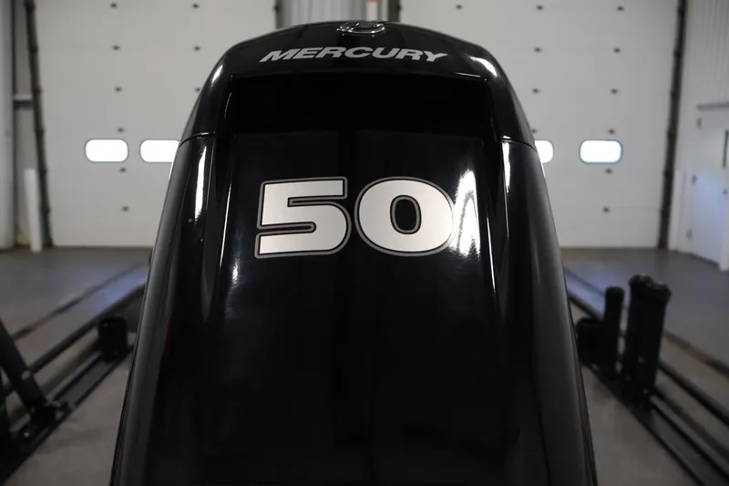 Slide: The Image of 2024 Tracker Bass Tracker Classic XL with Mercury 50 horsepower engine in a garage. - 43
