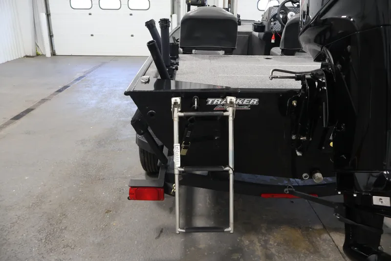 Slide: The Image of 2024 Tracker Bass Tracker Classic XL boat with ladder and motor in a garage. - 40