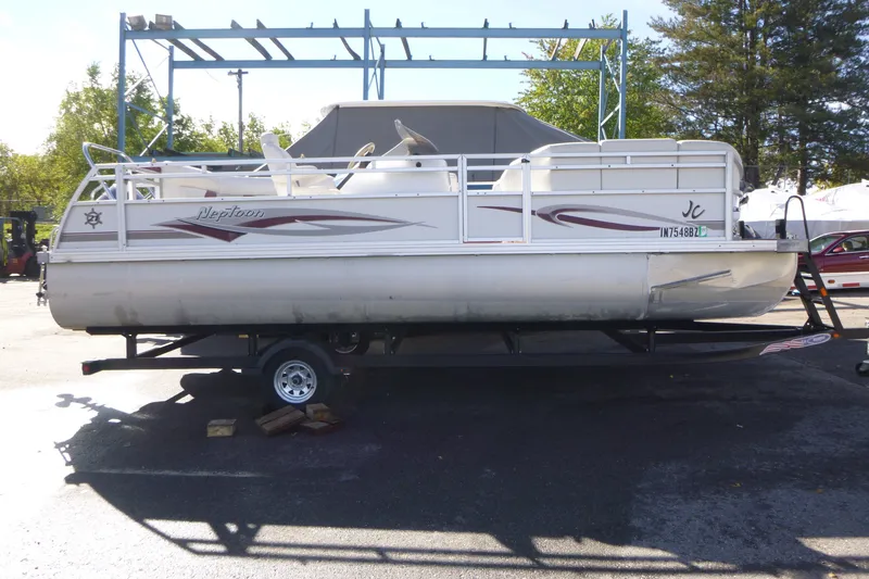 Slide: The Image of 2004 J 21' Neptune pontoon boat on trailer in outdoor setting. - 1